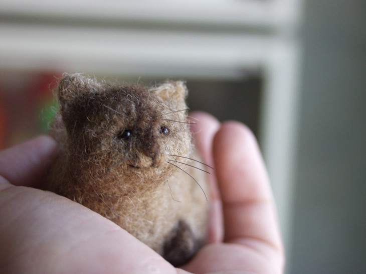 miniature needle-felted cat held in hand